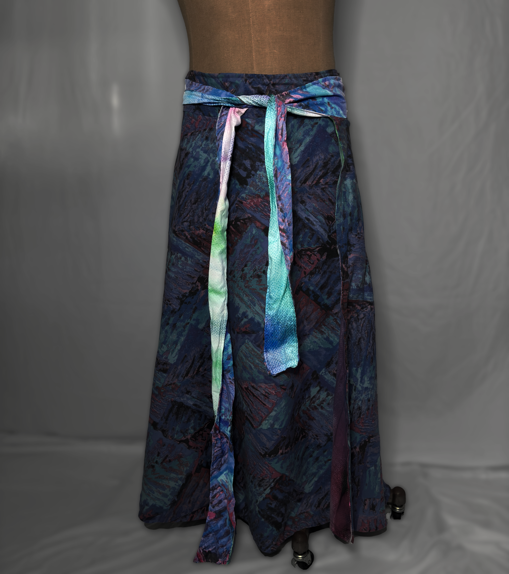Colorful patterned fabric skirt with a tied sash on a mannequin.
