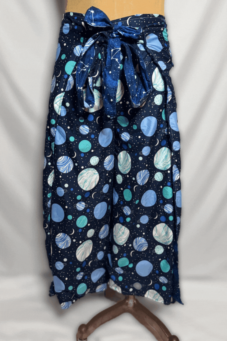 Black pants with a blue space-themed pattern featuring planets, stars, and moons, tied at the waist with a matching fabric belt.