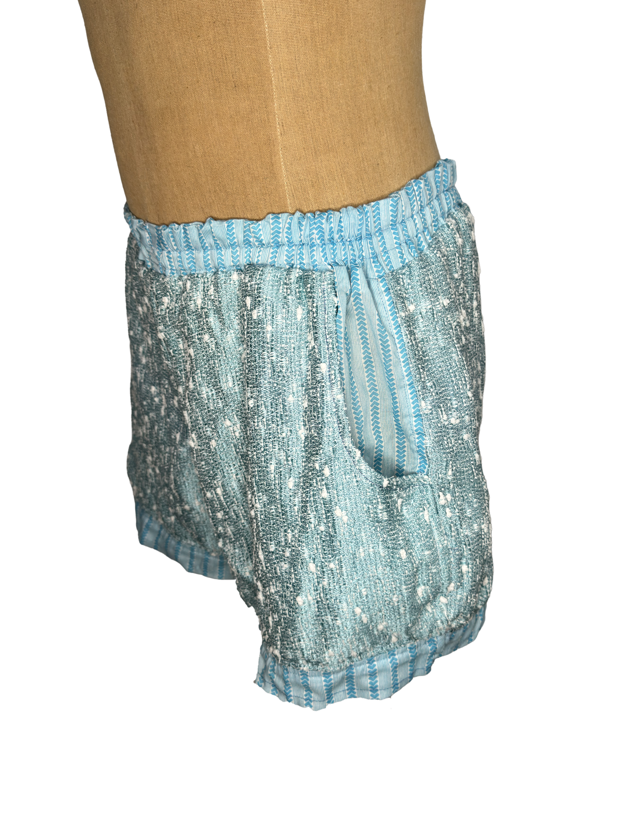 Two plaid shoulder bags, one in blue and red check pattern, the other in blue and white check pattern, displayed on a dress form.