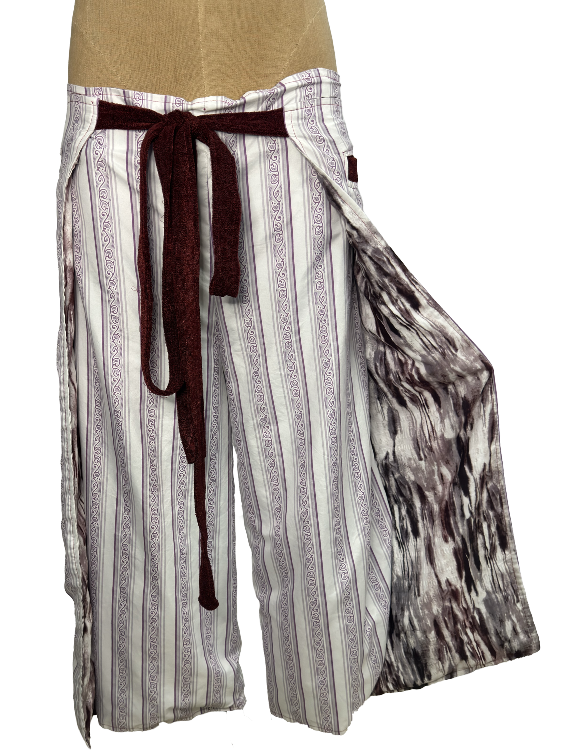 Pair of navy blue pajama pants with star constellations and galaxy patterns hanging on a mannequin.