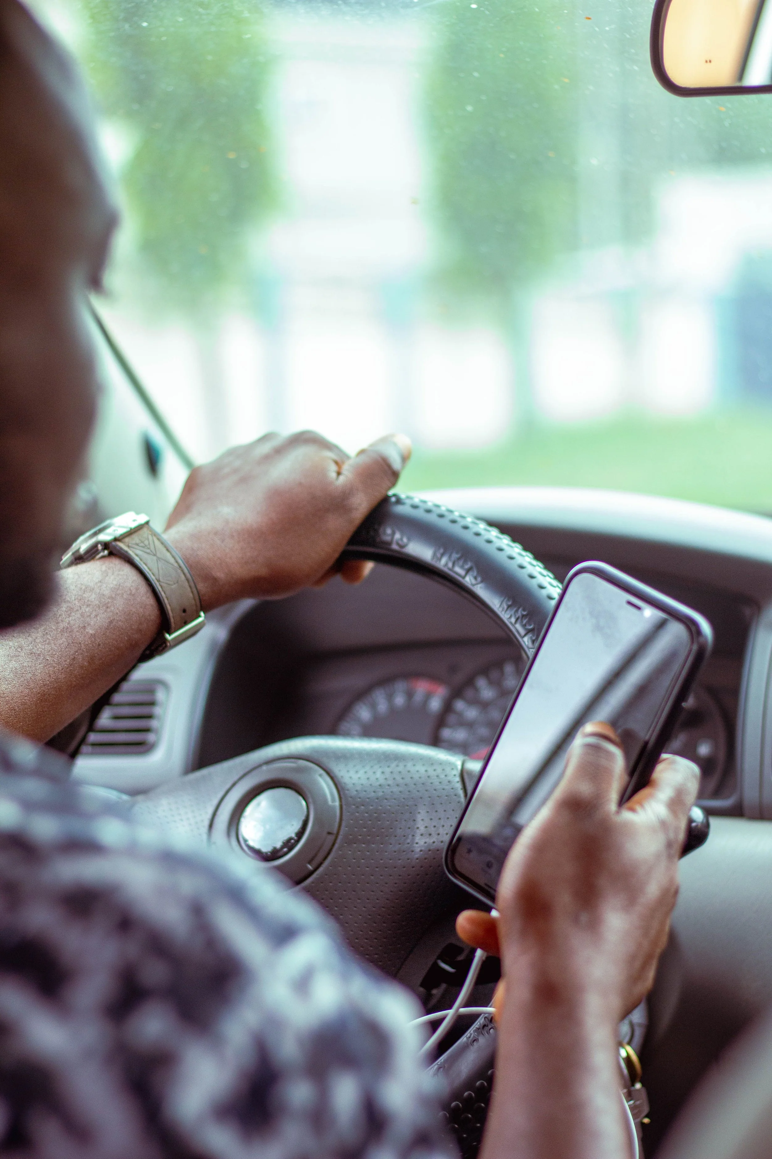 Hands resting on a steering wheel in soft afternoon light, representing the internal work of figuring out where you actually are with your family.