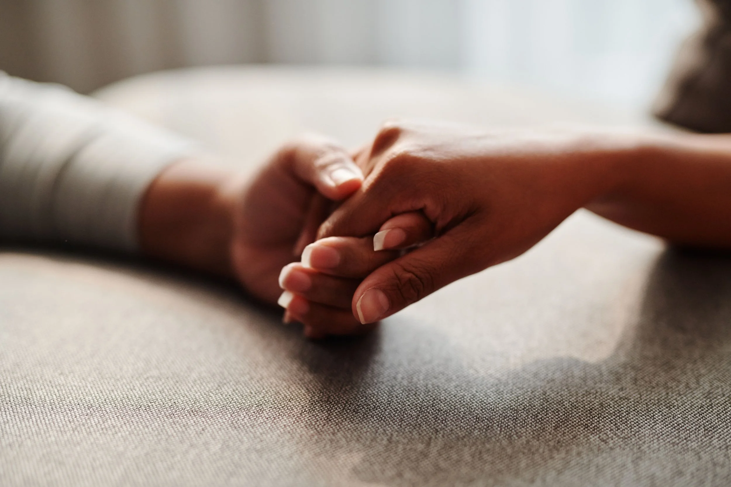 Two hands reaching toward each other, representing the support survivors of coercive control need in the healing process