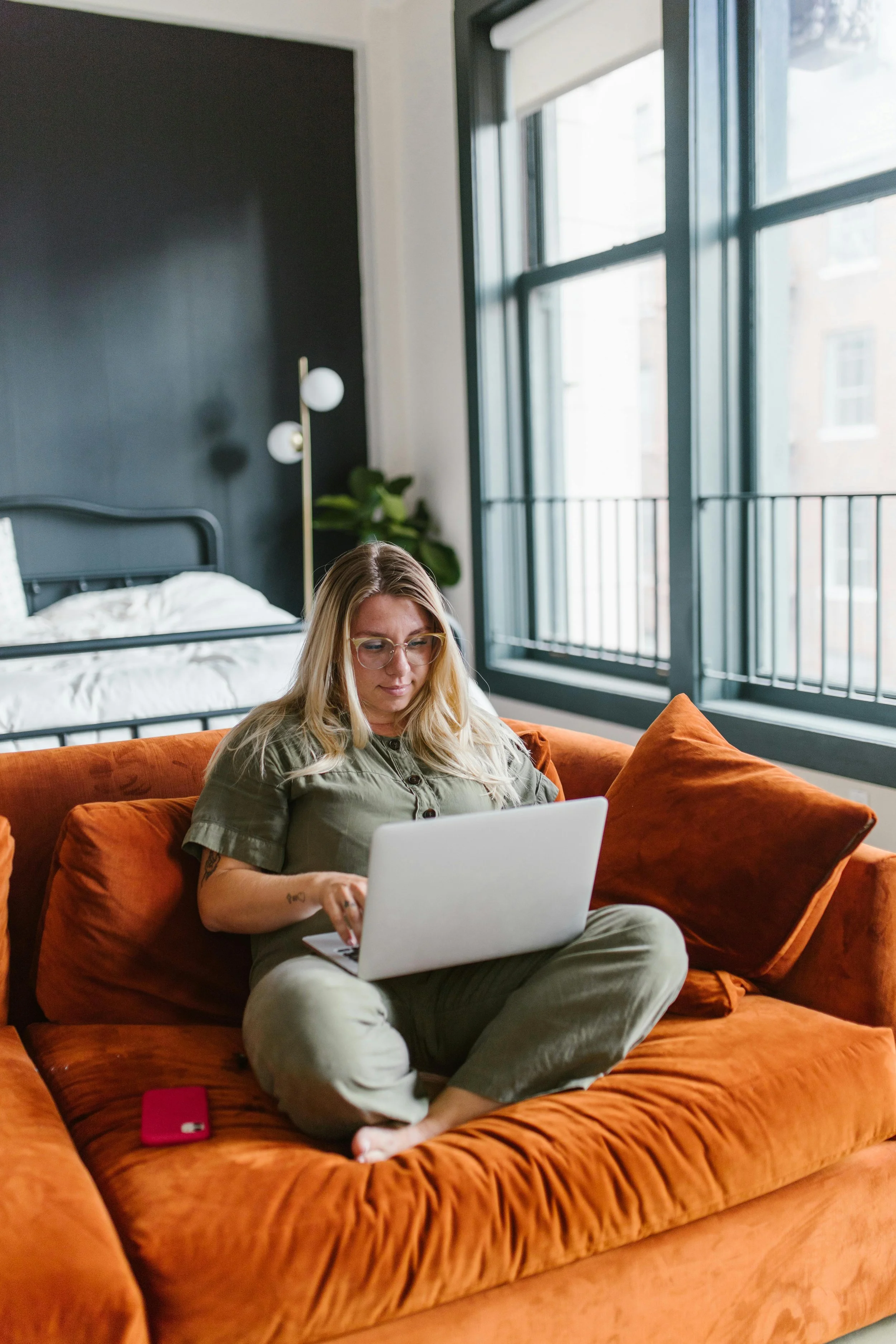 Woman sitting on a couch with a laptop, suggesting a quiet moment of reaching out and taking the first step