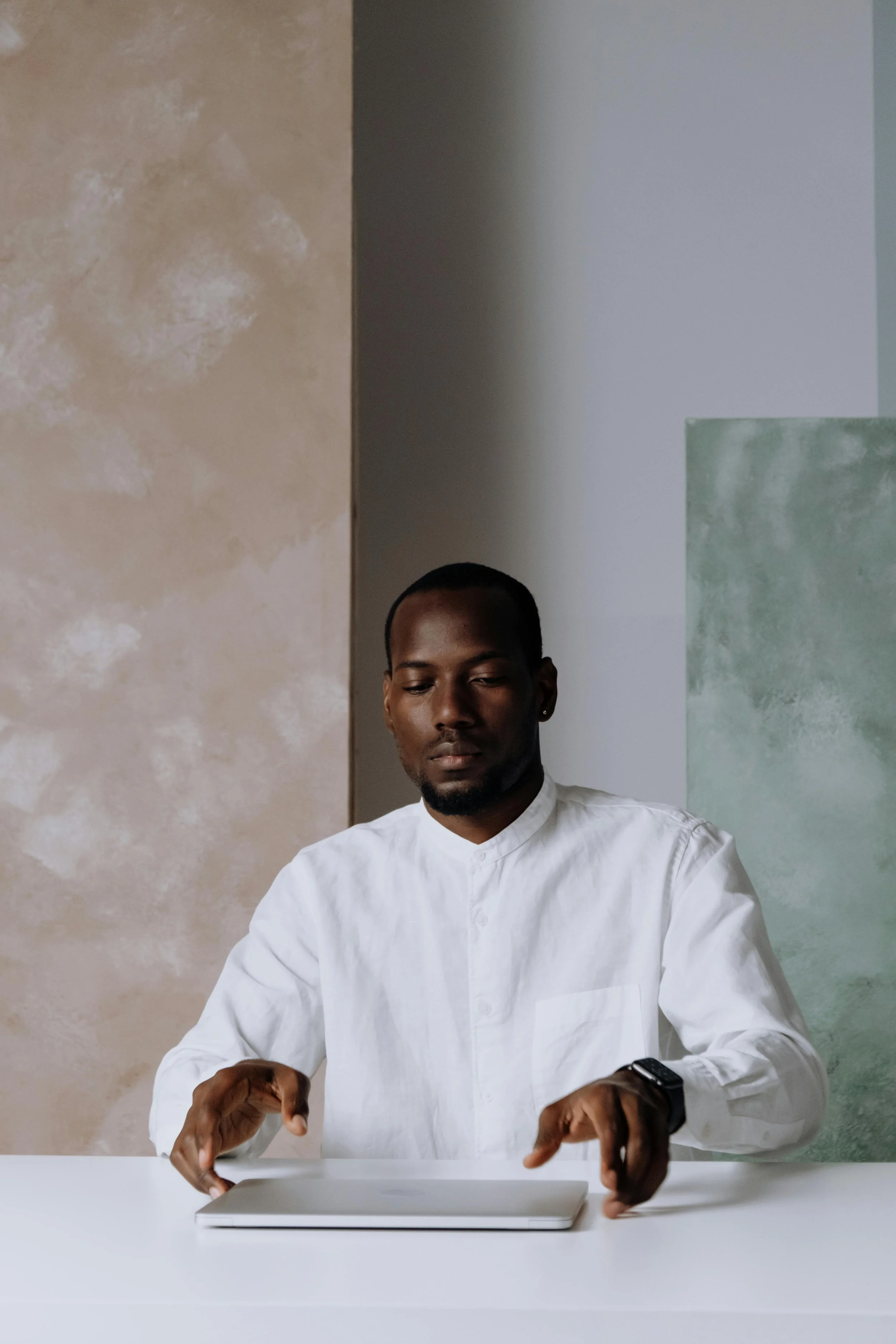A Black man in a white shirt with eyes closed in quiet reflection, evoking the internal weight of the forgiveness process