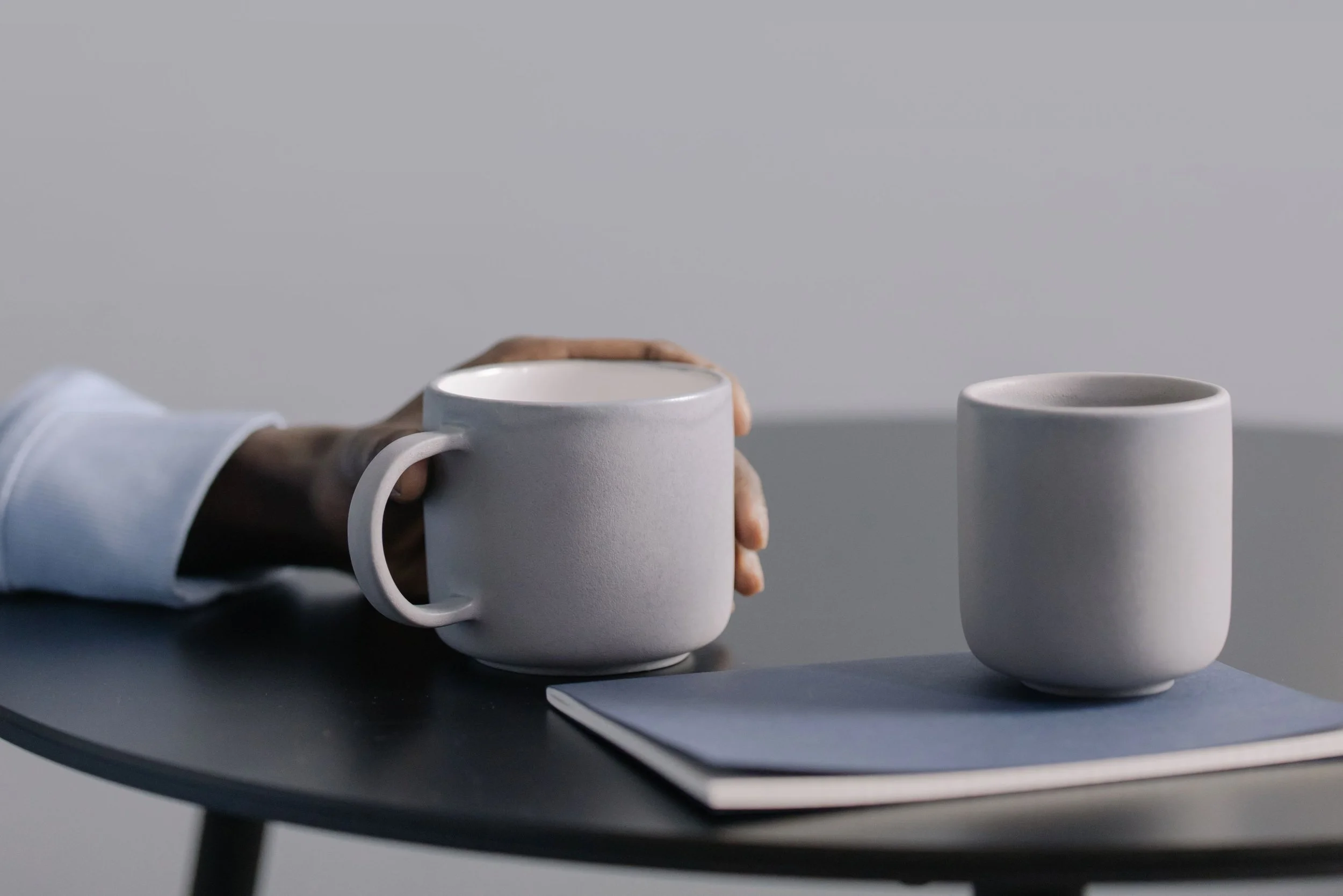 A pair of hands resting on mug, representing the settled inner posture that grief work can make possible.
