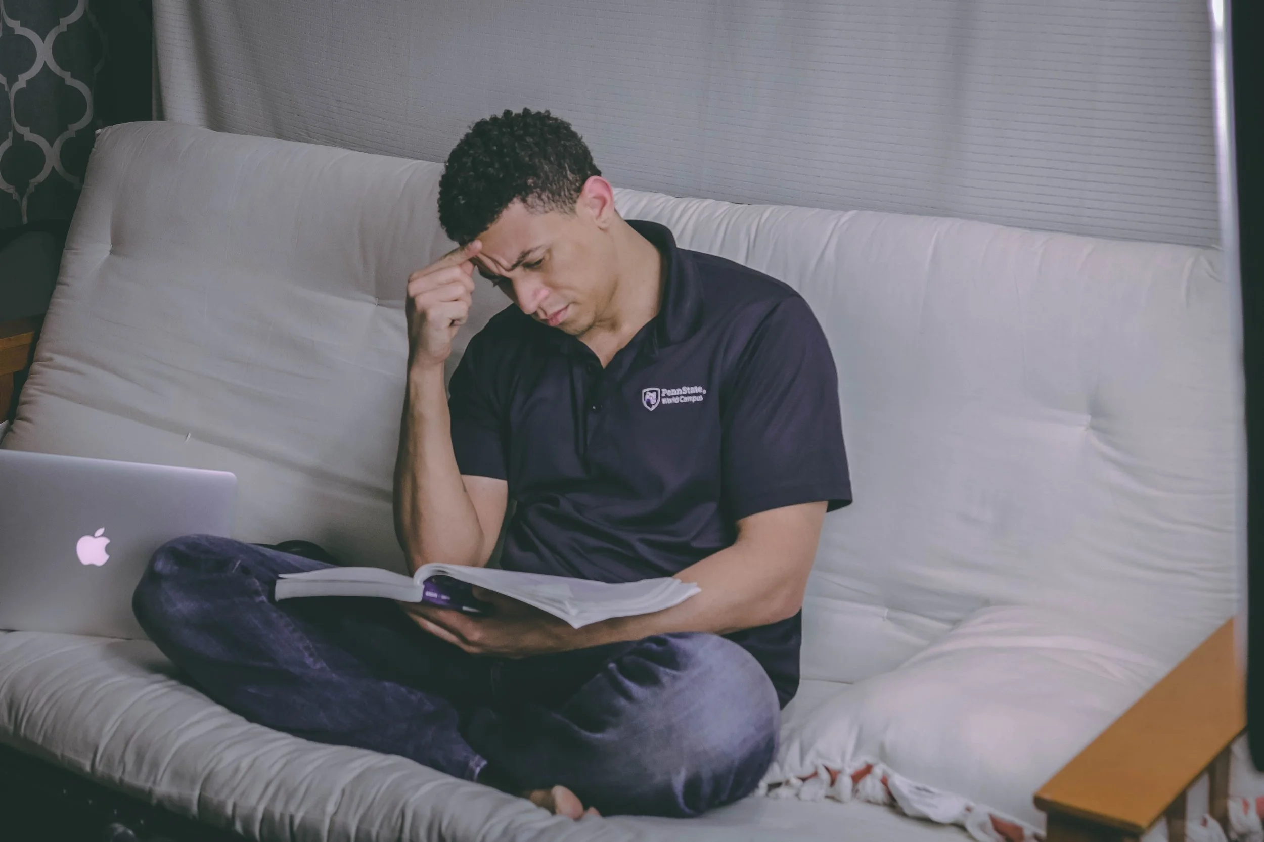An adult reading with a thoughtful expression, representing the moment a client recognizes their family pattern for the first time.