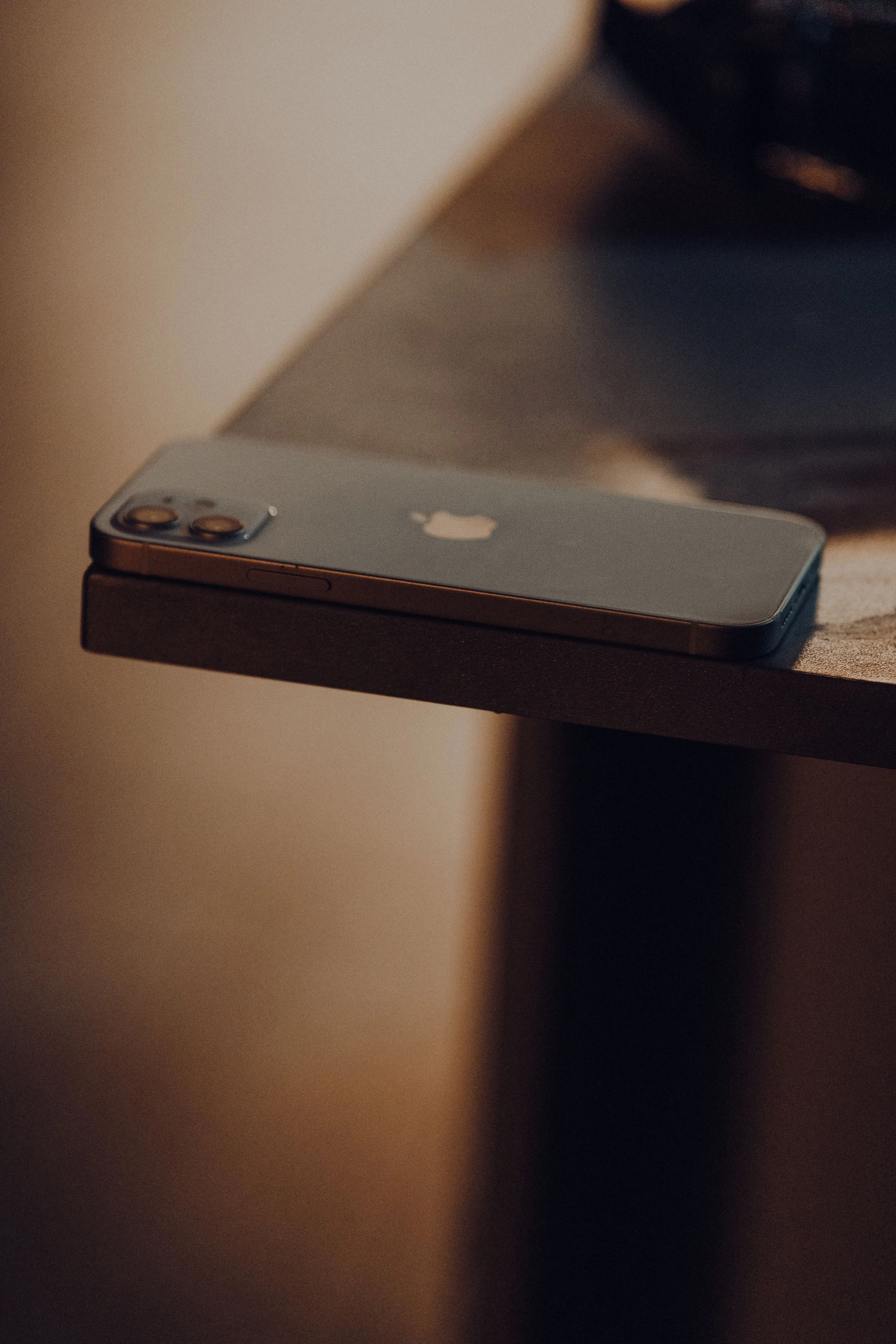 A phone lighting up on a table, representing the constant contact that defines coercive control