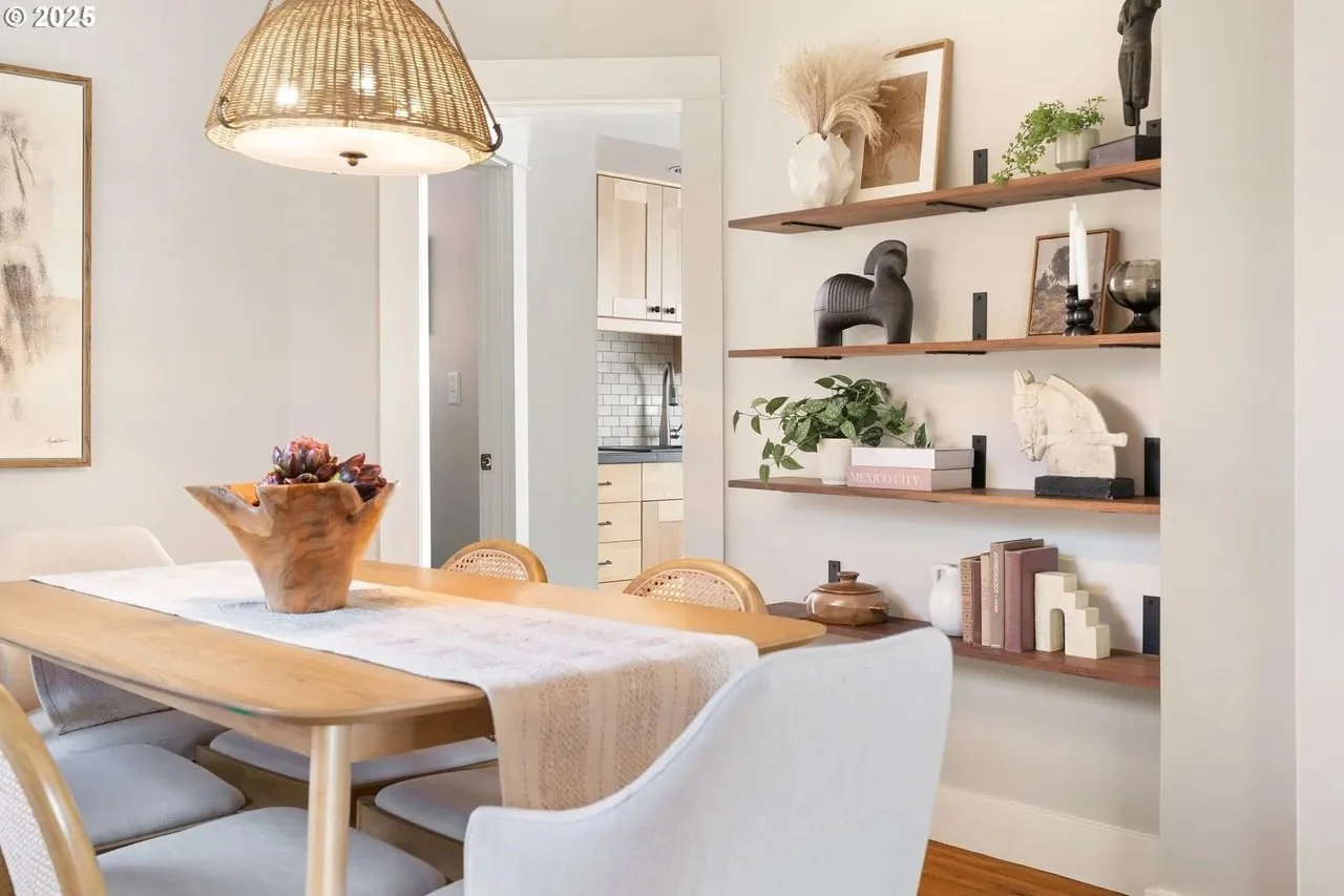 A natural dining room with an MCM table mixed with traditional dining chairs, and beautifully styled shelves. This home utilized staging to sell quickly. 