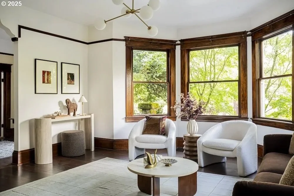 Bright craftsman living room with large bay windows in North Portland accentuated with charming home staging with a mix of collected vintage and modern pieces