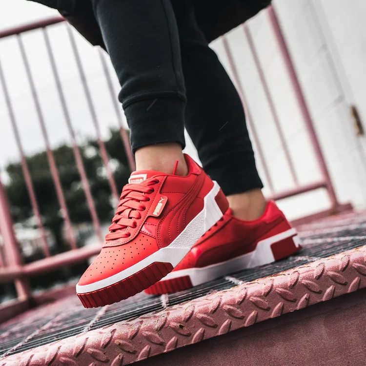Red sneakers on a red wall, product photo for Kicks USA
