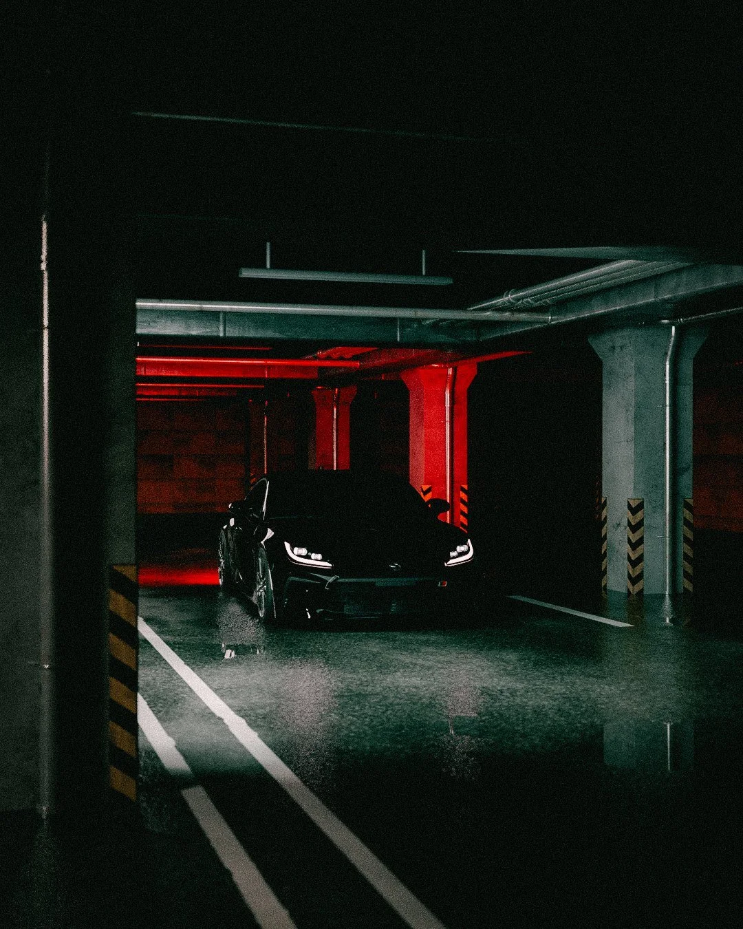 Black coupe framed between concrete pillars