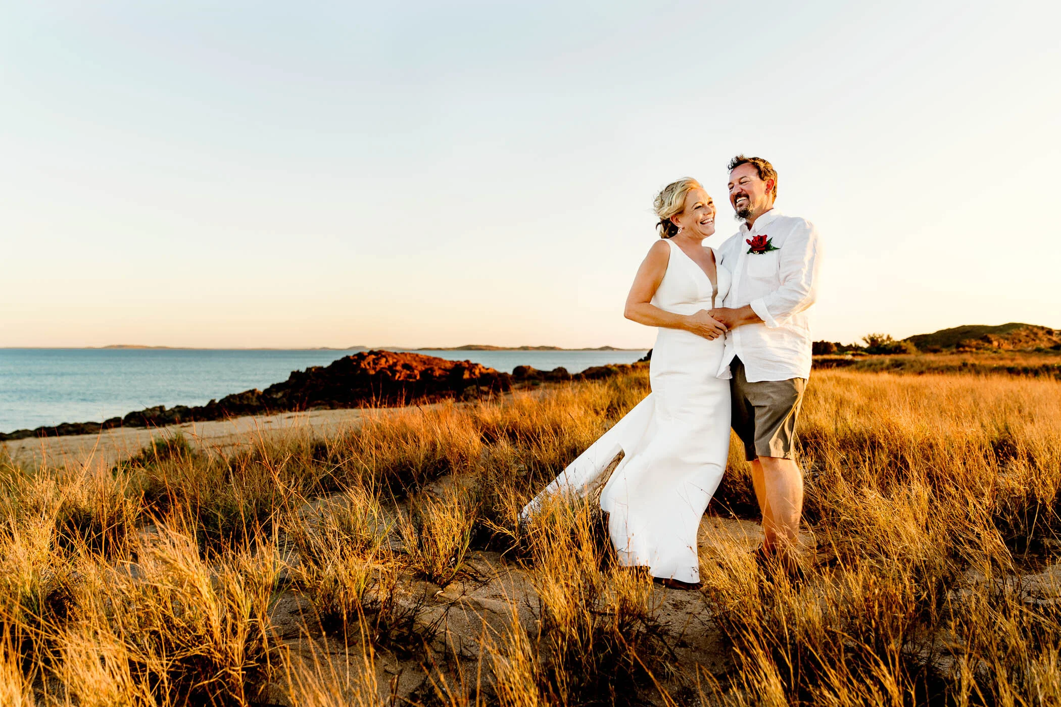 couple embracing in the sunset glow cast over the sand dunes at Point Samson WA
