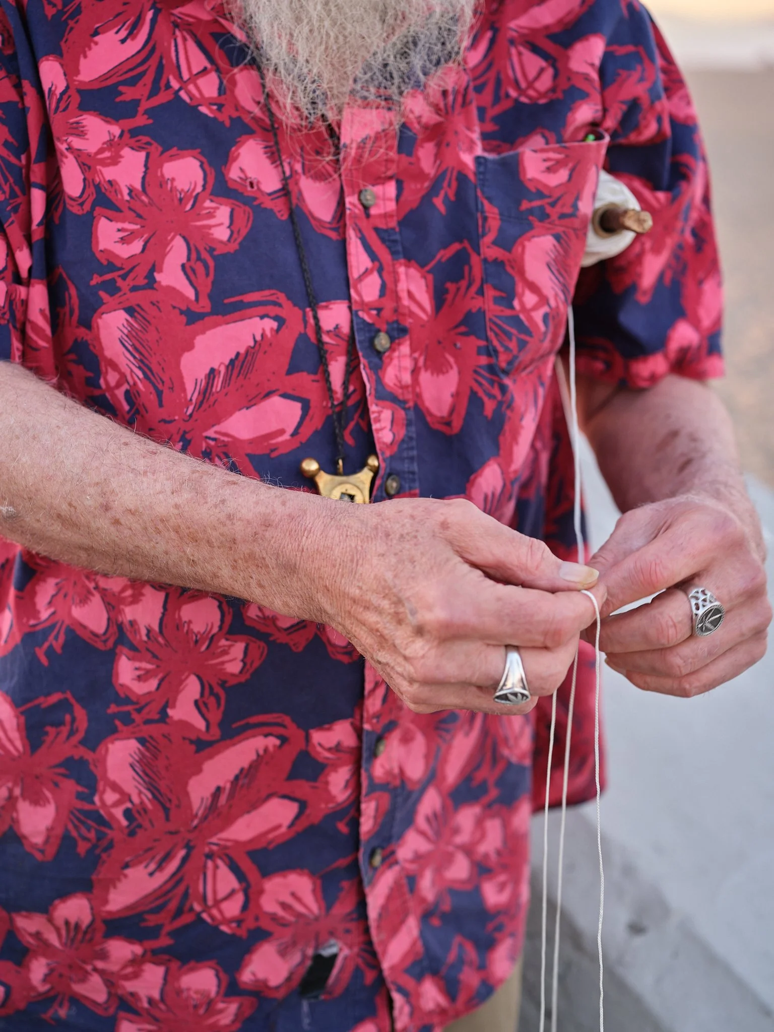 In this final scene, a man is shown gathering a white thread back into his hands. This act serves as a metaphor for the conclusion of a journey, the moment the tether is no longer needed because the destination has been reached. It represents the end