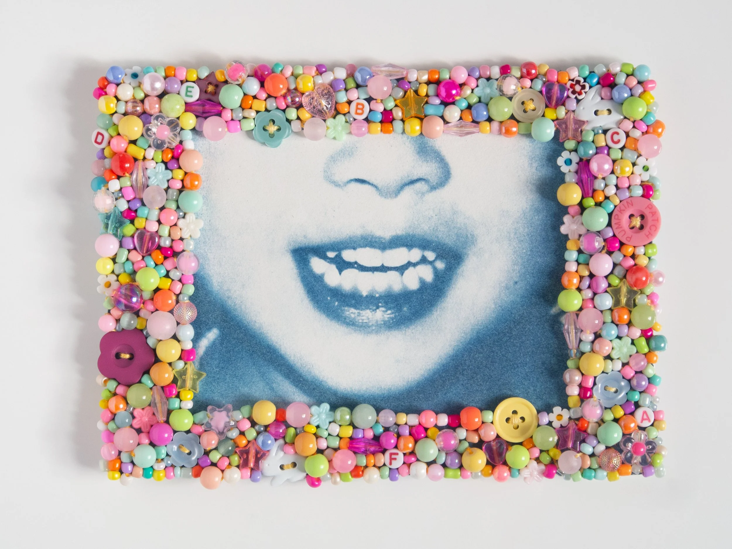 'does my smile still look the same?' 2026, Cyanotype embroidered with cotton thread and assorted beads, 14.5cm x 19 cm