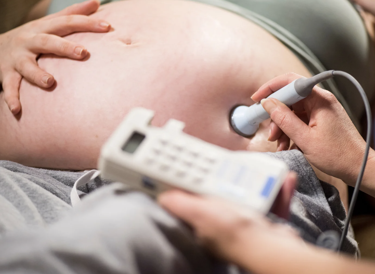 Jordmor lytter etter fosterlyd på en gravid mage