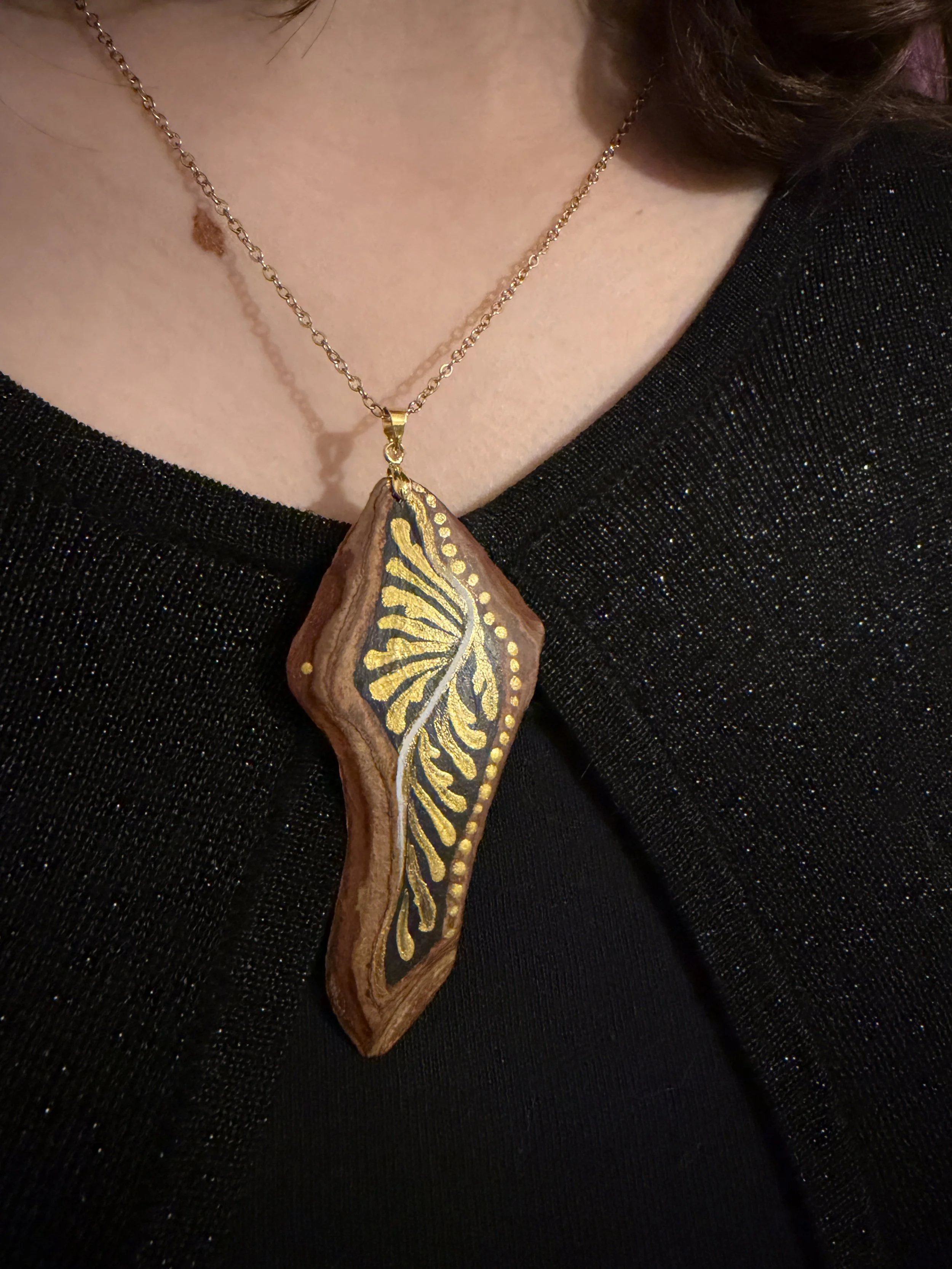 Fibratus hand-painted bark jewelry pendant worn — gold botanical motifs on natural bark, one of a kind wearable art by Bark & Grain Studio