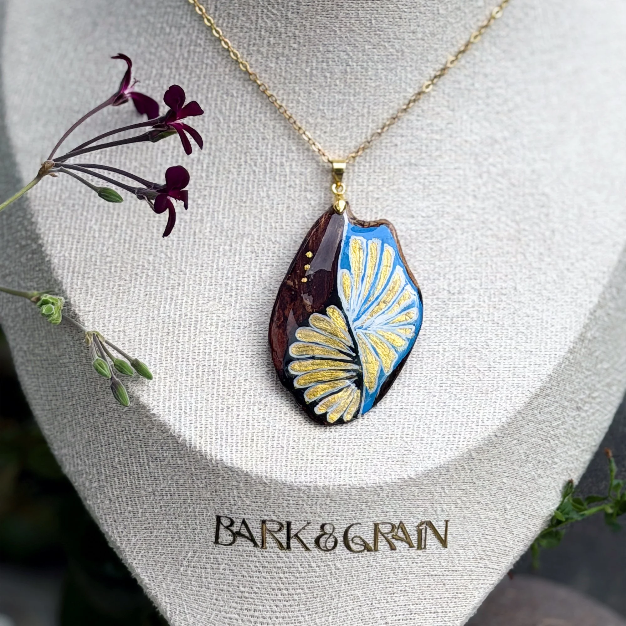 Celestrina pendant detail showing blue and gold striped fan pattern on reclaimed bark