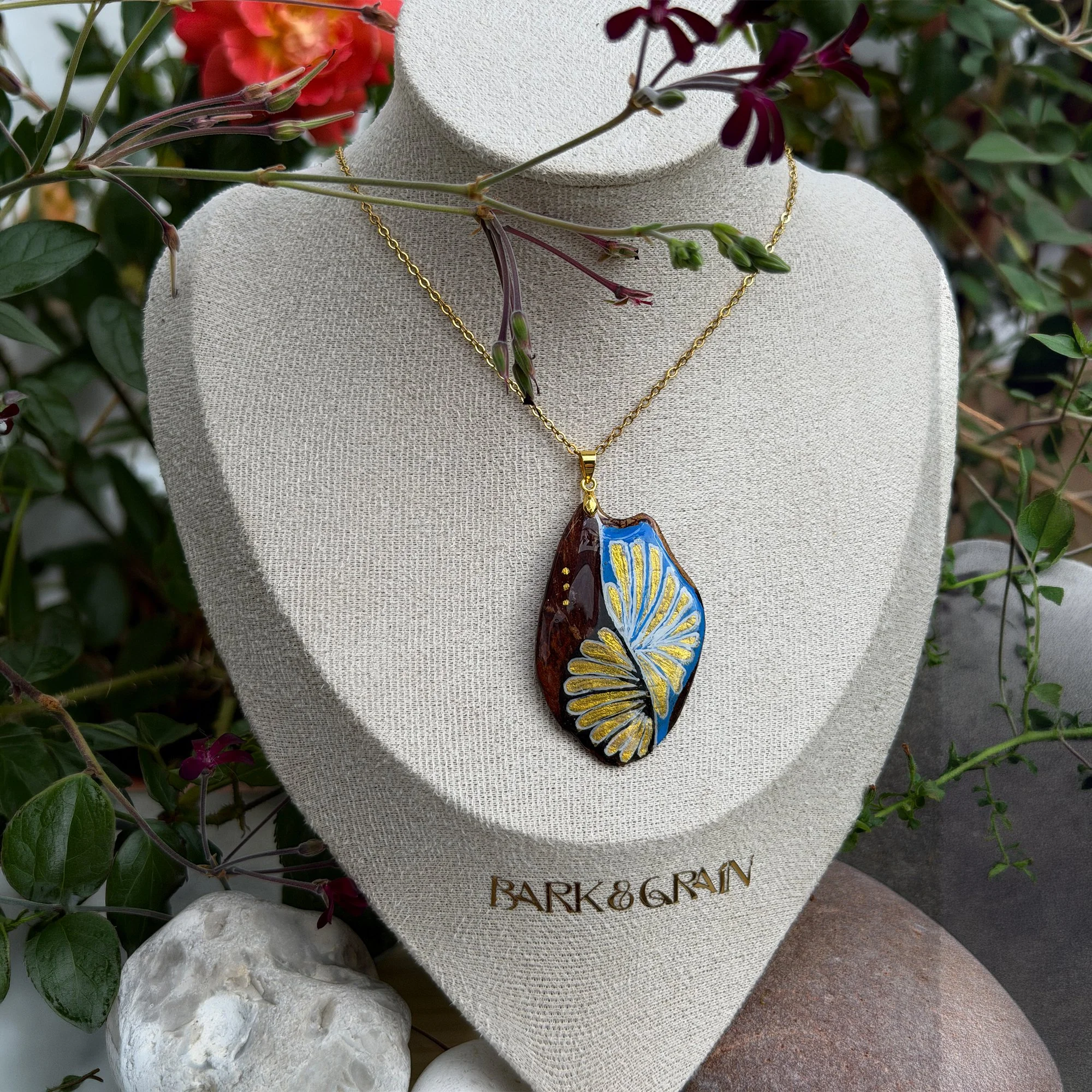 Hand-painted bark pendant necklace featuring azure blue and gold fan design