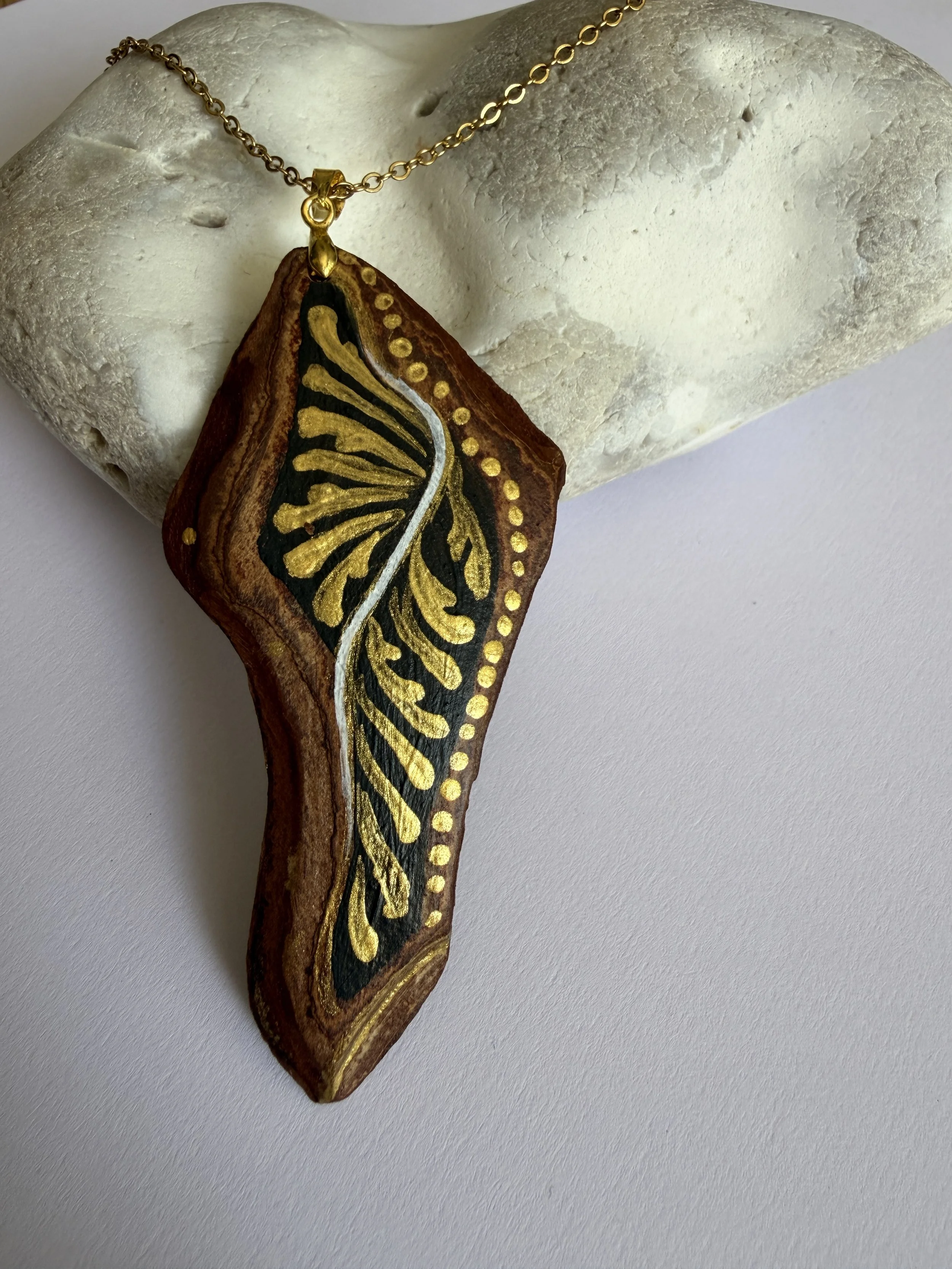 Fibratus bark jewellery close-up — 18k gold leaf detail on hand-painted bark pendant, nature talisman by Roxy Megyesi