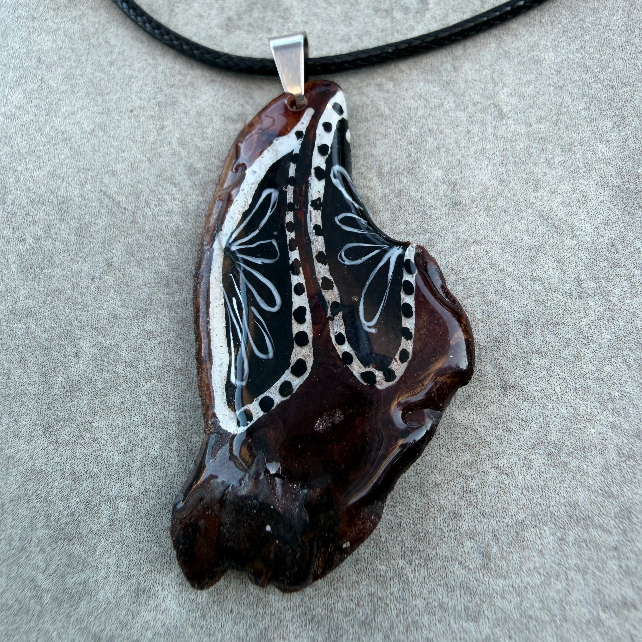 Moonveil hand-painted bark pendant on black waxed cord — white botanical motifs on dark bark, by Roxy Megyesi, Bark & Grain Studio