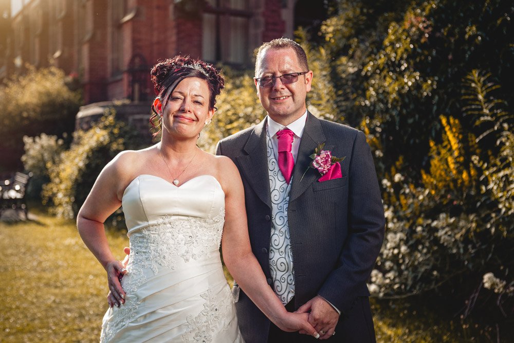 bride and groom pose at Bestwood Lodge, Nottingham on a summer evening