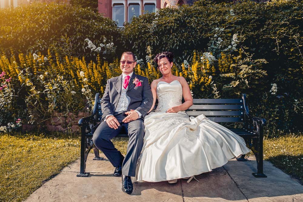 bride and groom sit in the gardens at Bestwood Lodge Nottingham