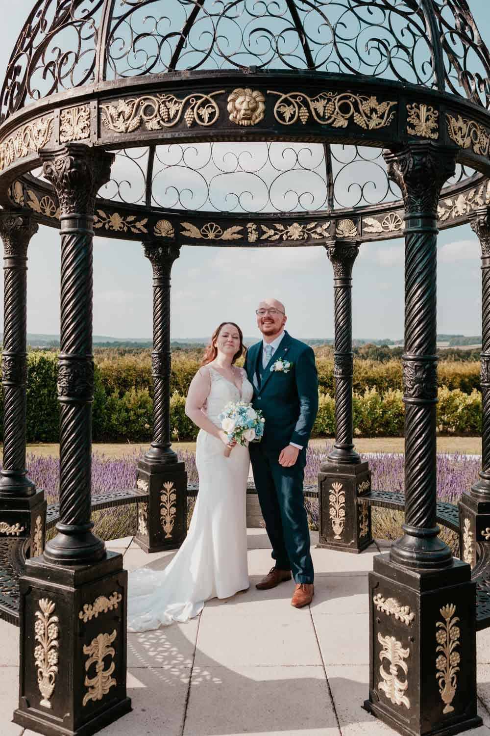 happy couple pose under the pergola in Goosedale lavender garden