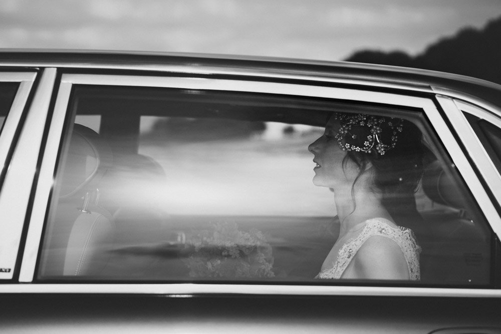 bride arrives at church in Jaguar classic car