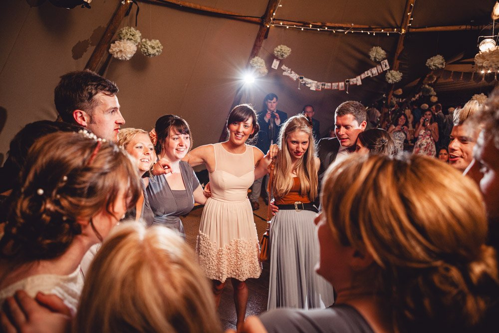 guests dance in a large circle in a tipi wedding