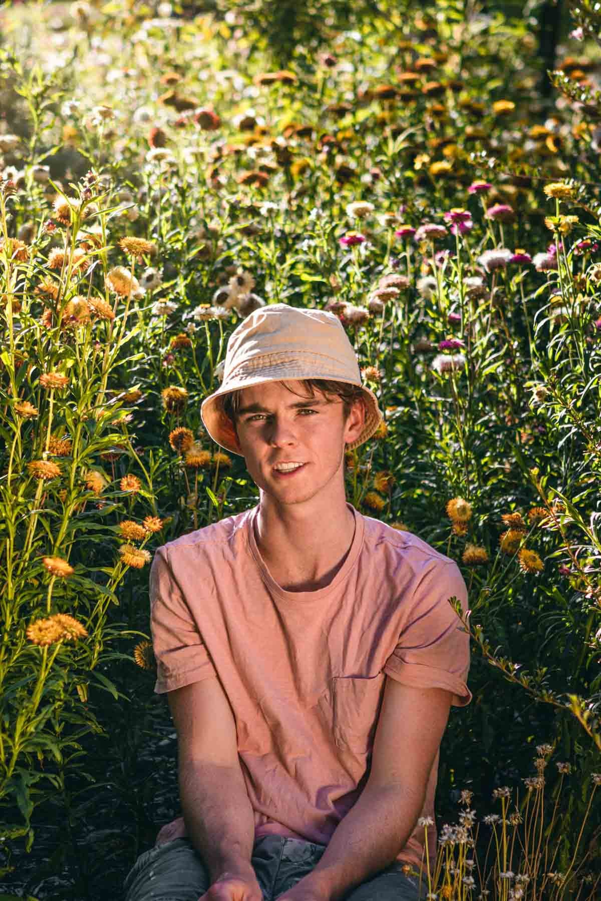 Adelaide singer Ashton Fraser sits in a flower meadow