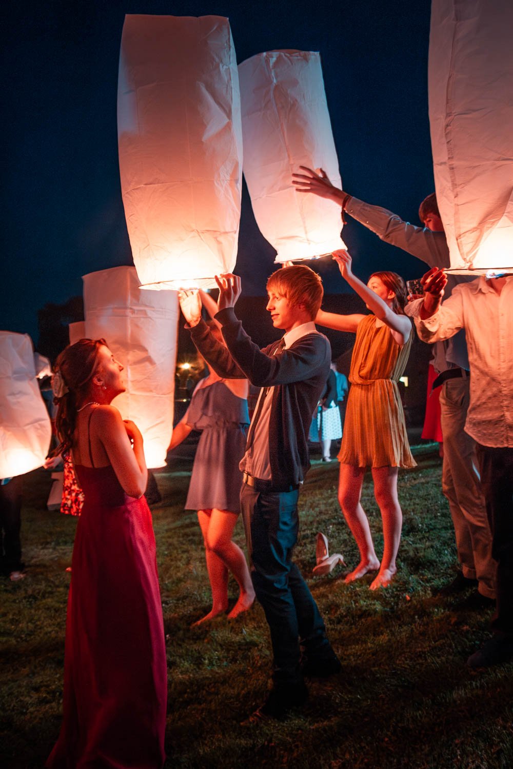 guests launch paper lanterns into night sky