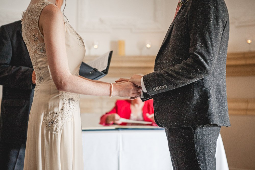 bride and groom hold hands during wedding ceremony