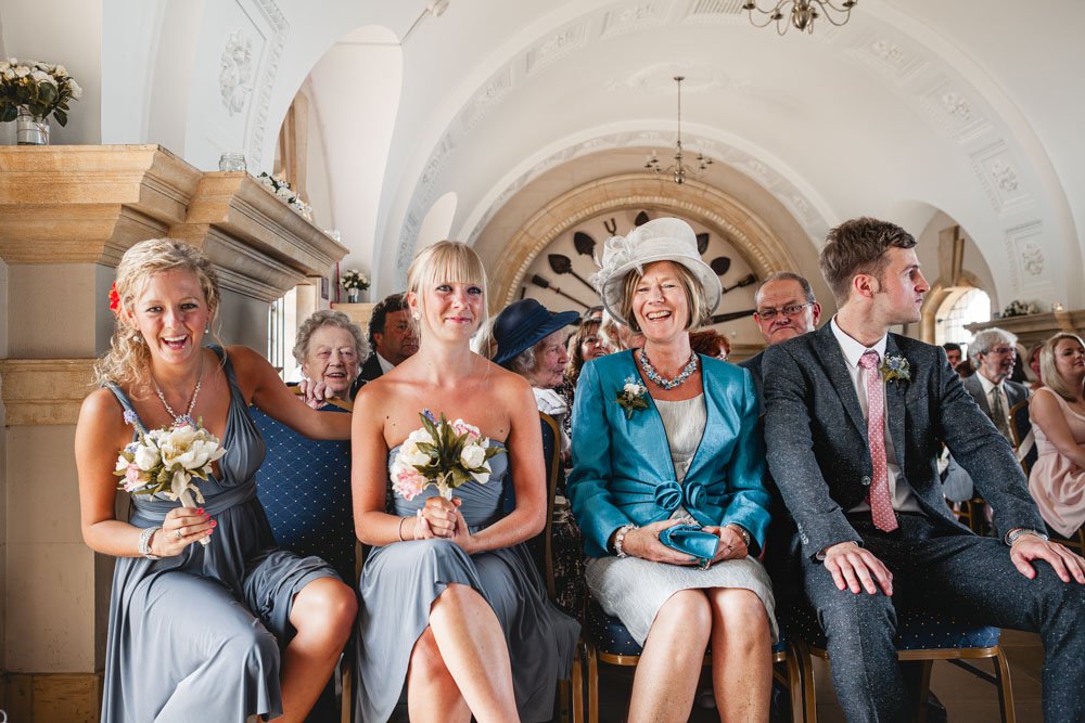 front row of the congregation laugh during wedding ceremony