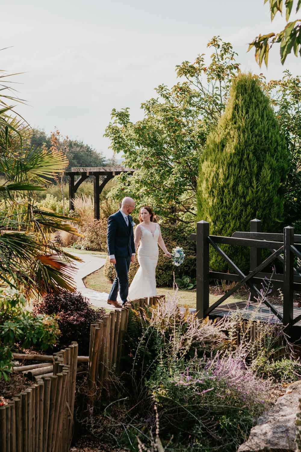 bride and groom walk in the garden at goosedale