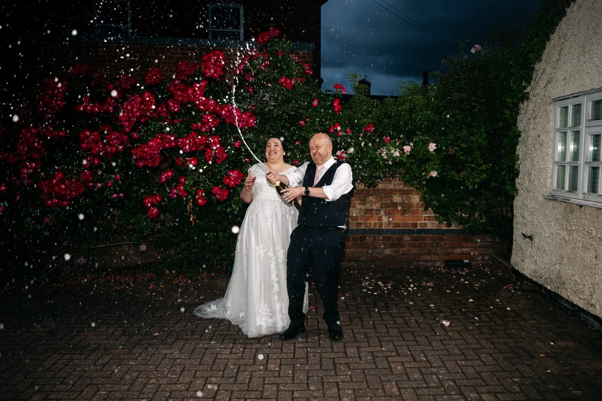 bride and groom spray champagne at a wedding at the Cottage Hotel in Ruddington, Nottinghamshire