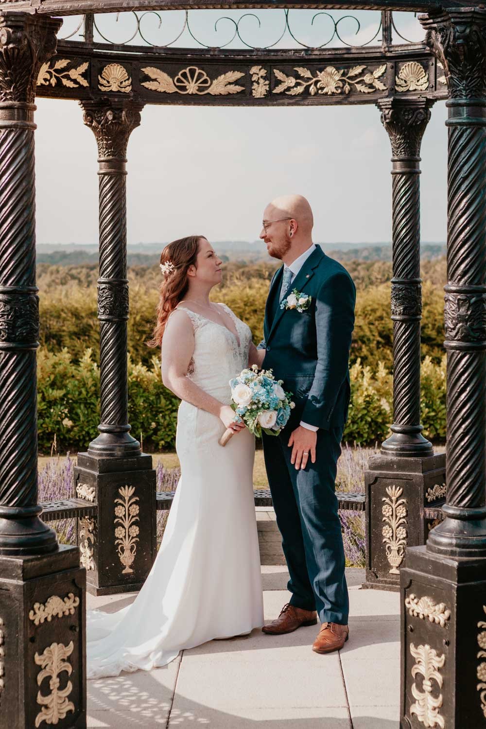 bride and groom look lovingly at each other in wedding garden