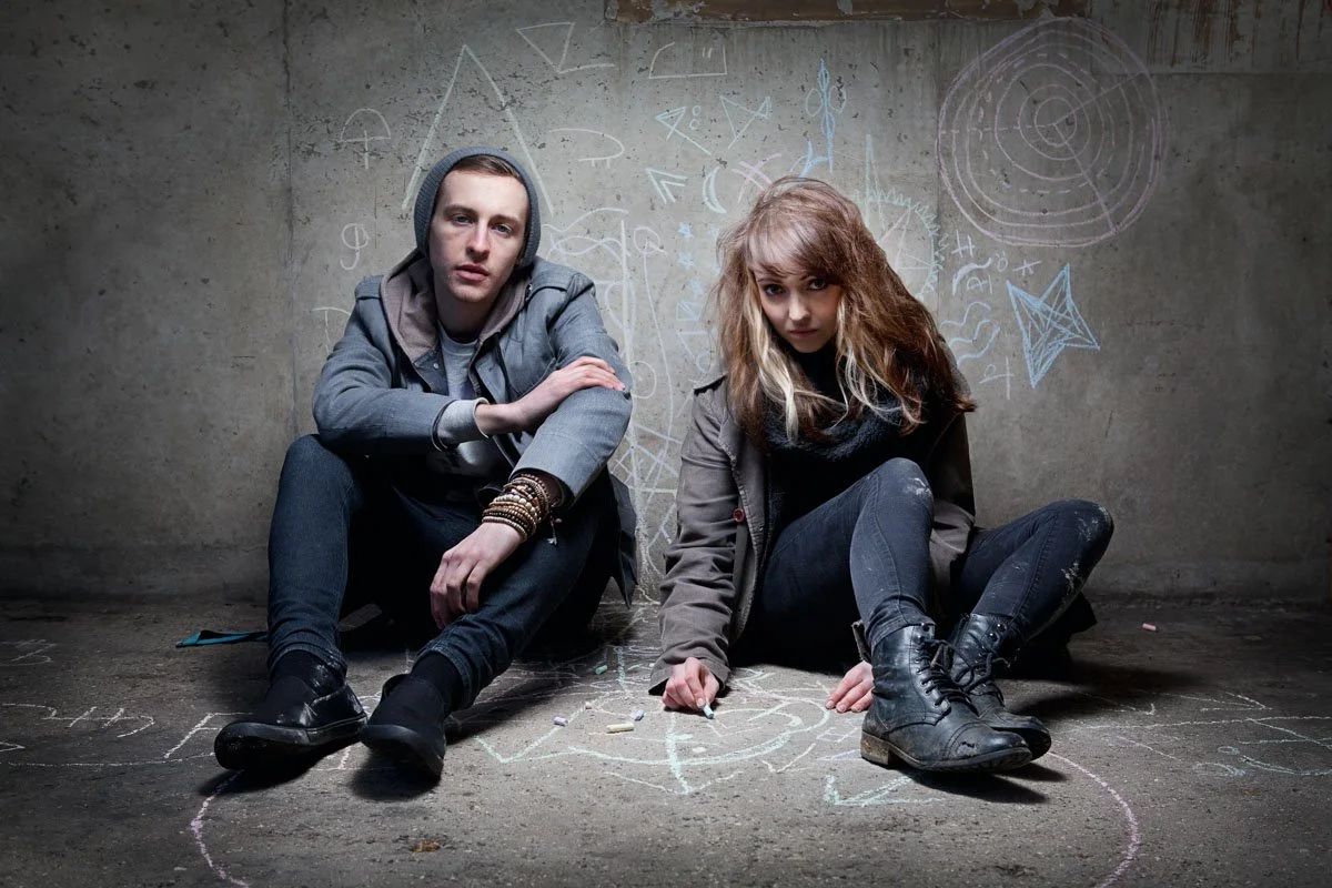 Photoshoot with music duet Anavae in a car park, with cult symbols drawn on the ground