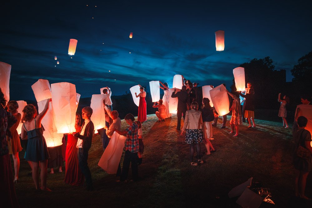 wedding party launches paper lanterns into the night sky