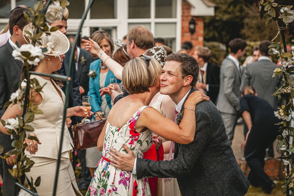 groom greets guest at garden wedding