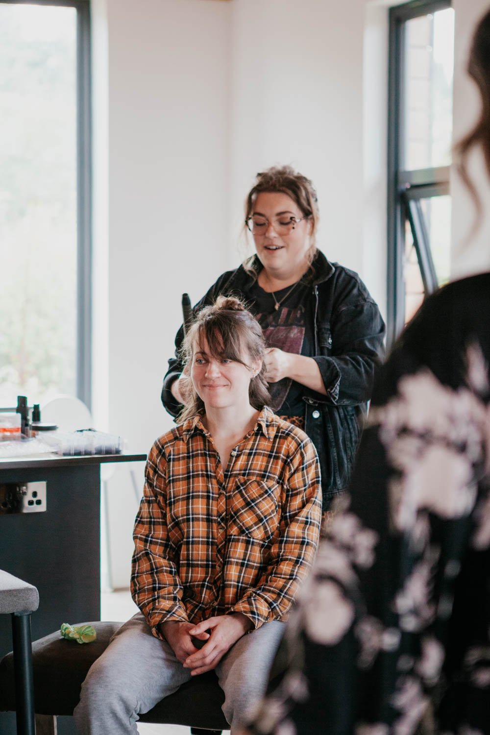 make-up artist dresses hair of a bridesmaid