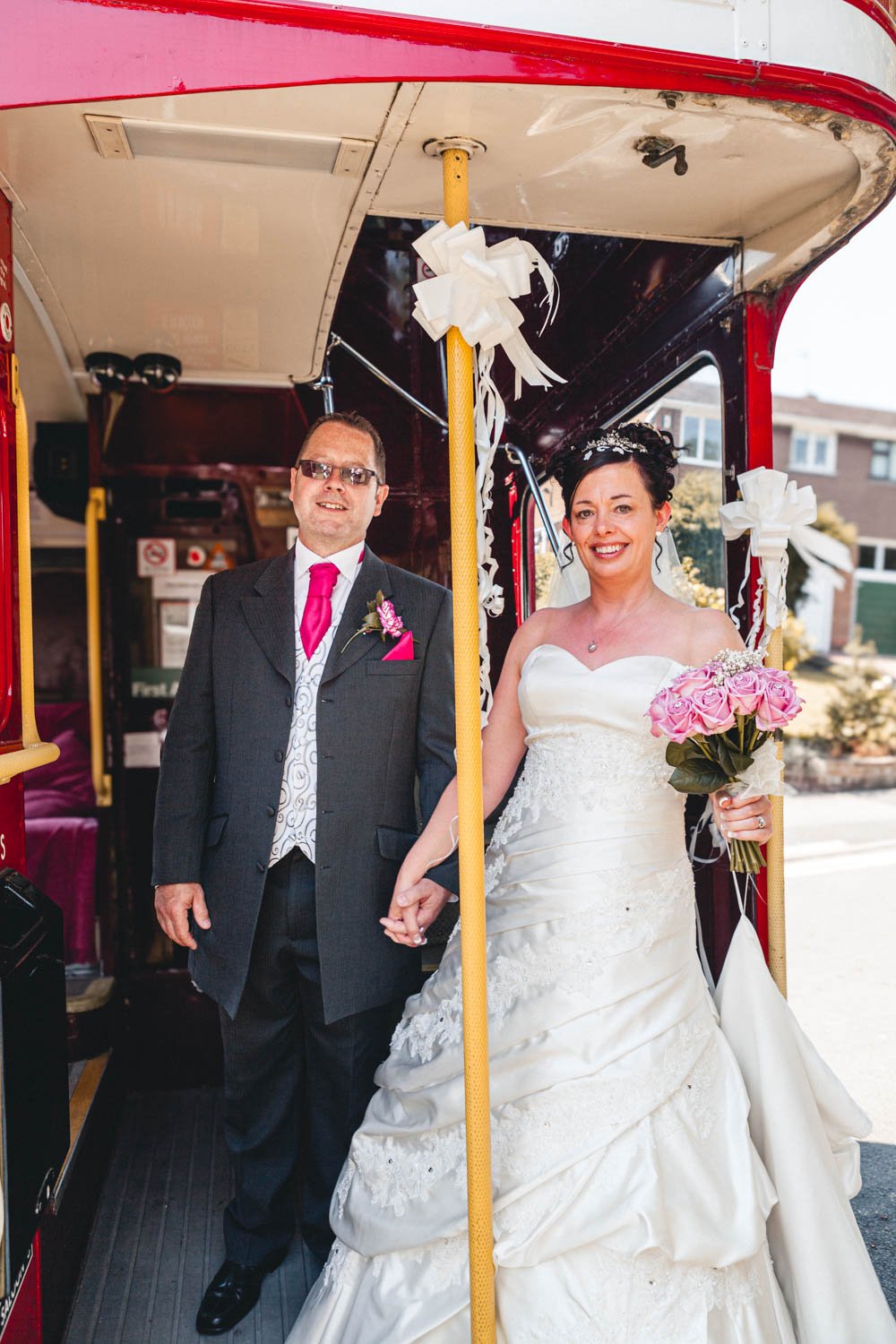 bride and groom on a double decker wedding bus