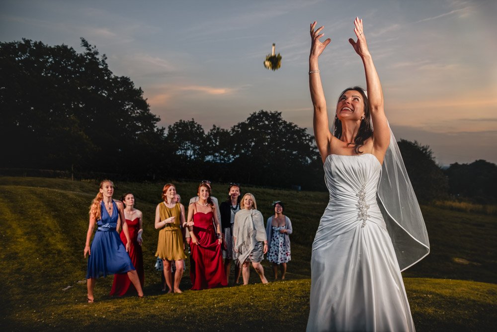 Bride throws bouquet for bridesmaids to catch