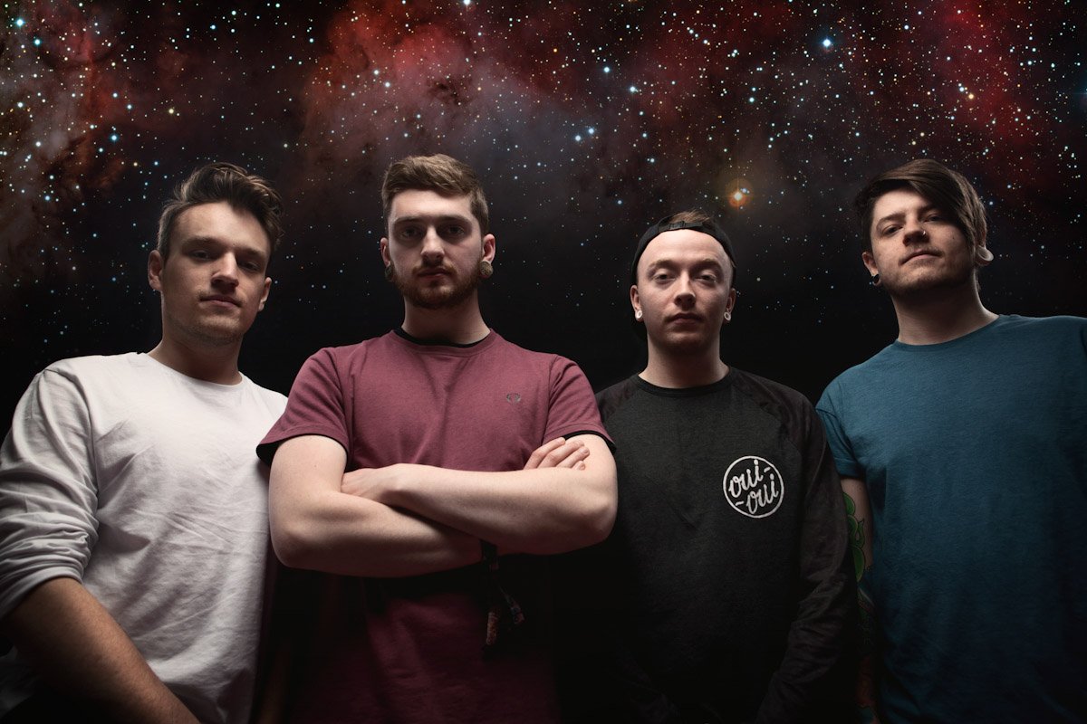 tech-metal band Confluence stand in front of a starry nebula background