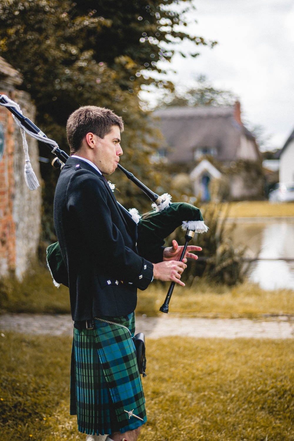 bagpiper in a kilt greets guests in Haddenham Oxfordshire
