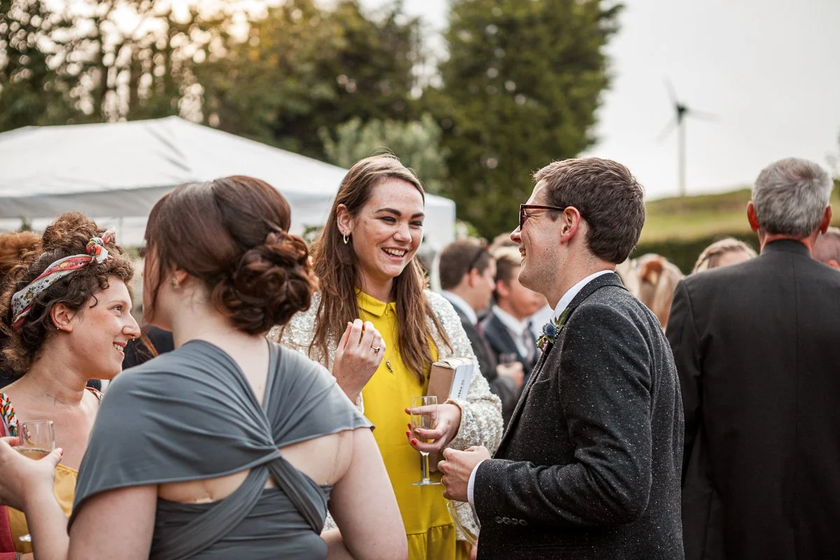 groom chats to guests at garden reception