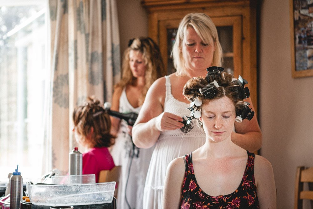 bride has her hair styled during bridal preparations