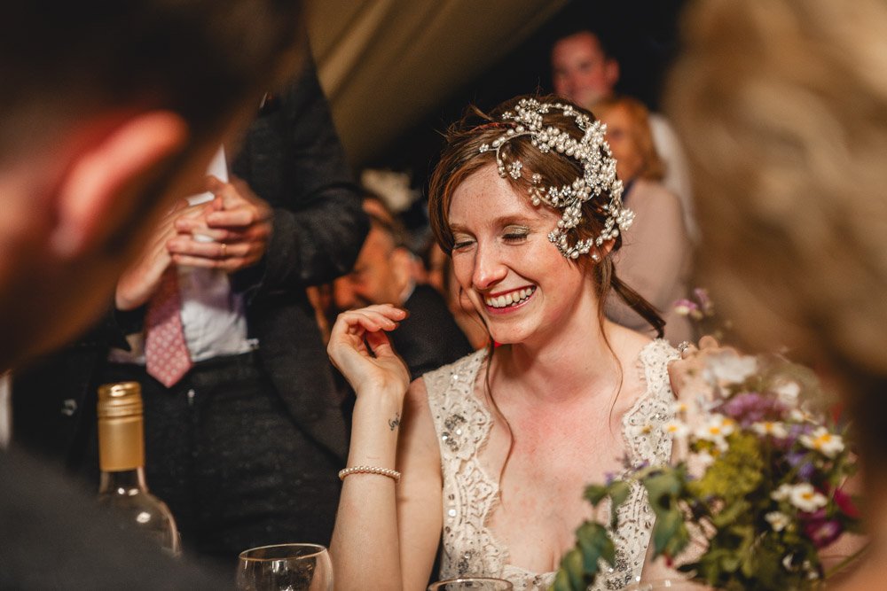 bride laughs during the groom's wedding speech