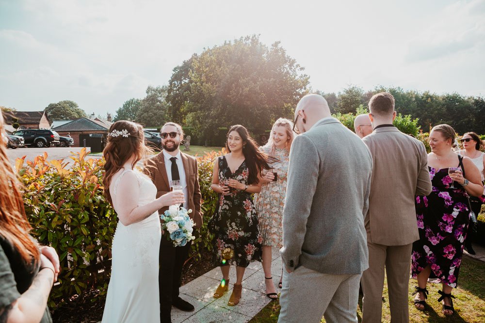 bride greets guests in the garden at a Goosedale wedding
