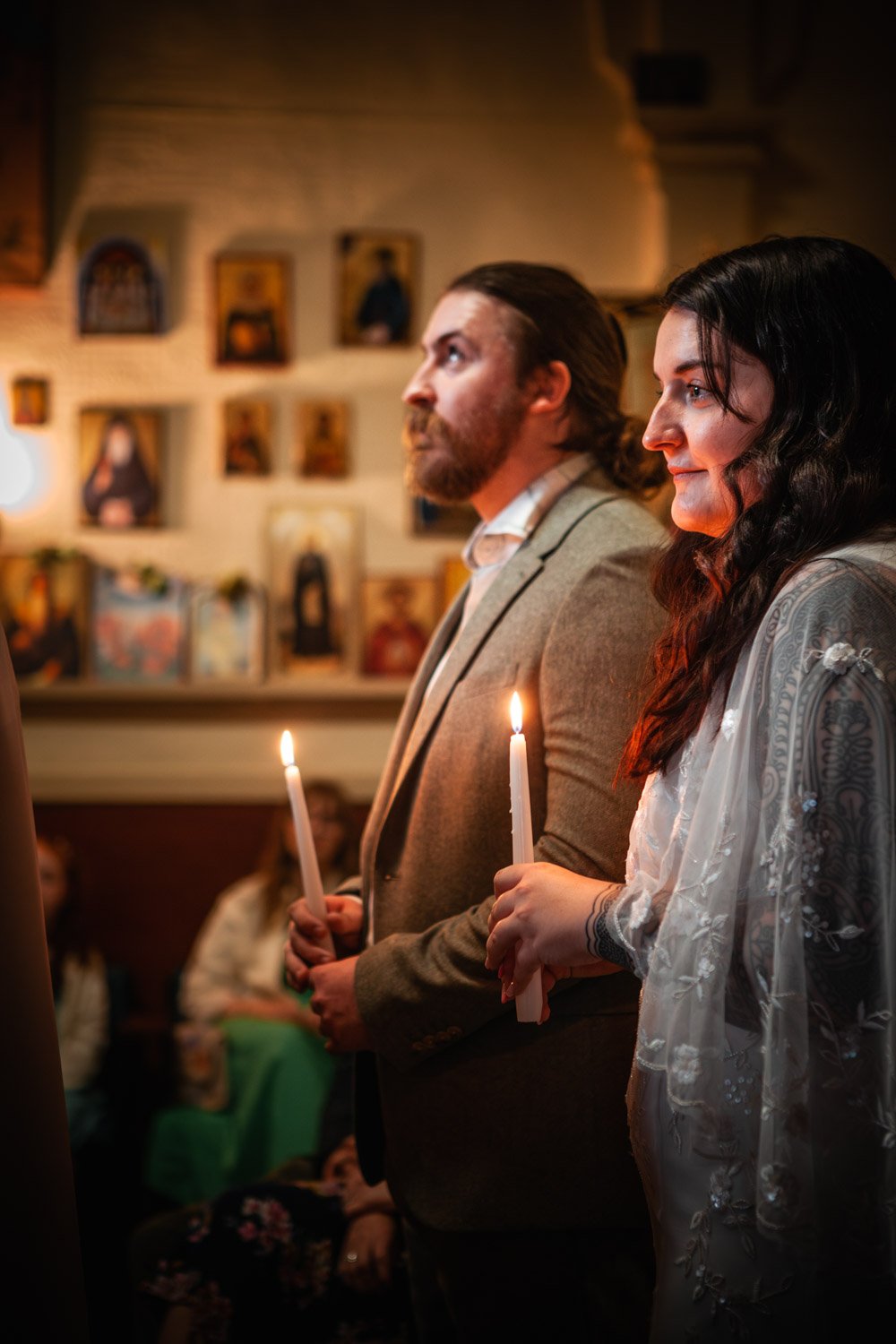 bride and groom hold candles in Christian orthodox ceremony