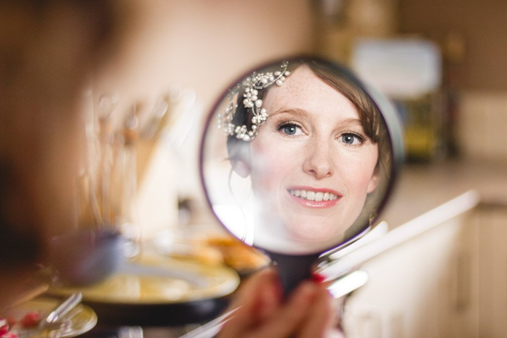 bride looks at her reflection in mirror during bridal preparationsv